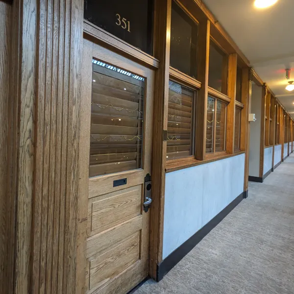 Room entrance with wooden blinds looking out into atrium